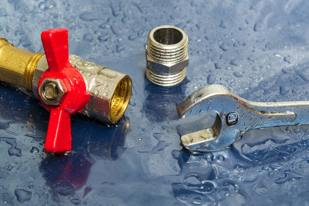 Wasserhahn und Schraubenschlüssel in Wassertropfen bei Reparatur von Geräten während eines Unfalls - Foto, Bild