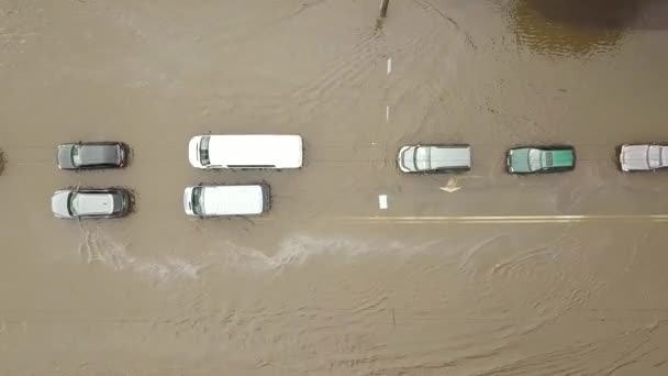 Sel basmış yolda yağmur suyu ile giden trafik arabalarının hava görüntüsü. - Video, Çekim