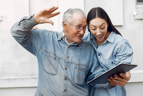 Girl teaching her grandfather how to use a tablet - Zdjęcie, obraz