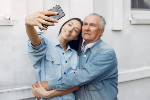 Girl teaching her grandfather how to use a phone - Foto, afbeelding