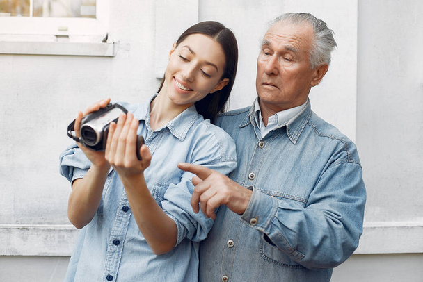 Girl teaching her grandfather how to use a camera - Zdjęcie, obraz
