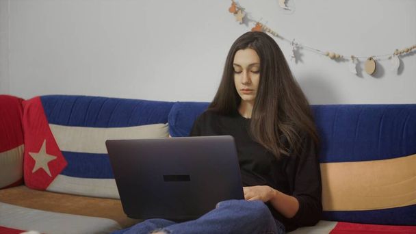 Young freelancer Working Home on Laptop Sitting in Comfortable Sofa. Freelancer Female Blogger Working at Home With Laptop. Blogger Journalist Works Remotely. - Photo, Image