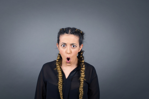 Headshot van gekke verrast bug-eyed jonge vrouw dragen casual zwarte blouse staren naar camera met geschokte blik, uiten van verbazing en schok, schreeuwen Omg of Wow - Foto, afbeelding