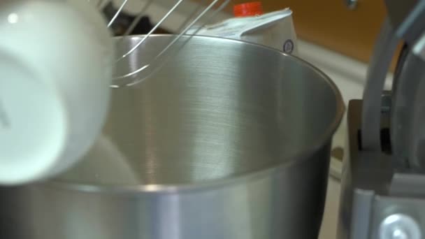 Vrouw hand toevoegen van suiker aan mixer zweepslagen zoete room voor een taart. - Video