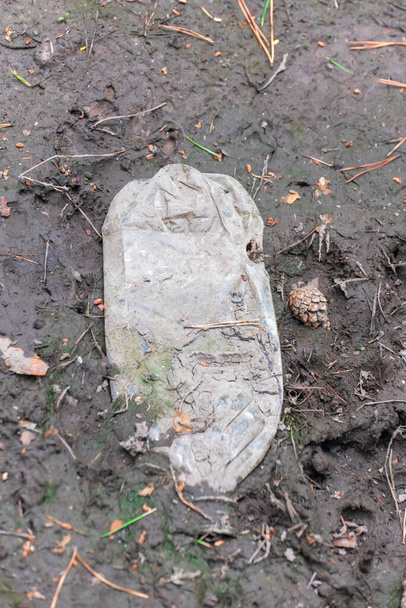 Κρυμμένο παλιό πλαστικό μπουκάλι που βρίσκεται στη λάσπη - Φωτογραφία, εικόνα
