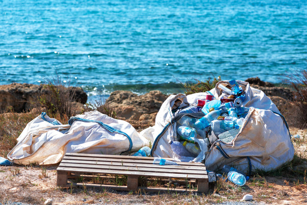 Σακούλα σκουπιδιών σε μια άγρια παραλία δίπλα στη θάλασσα - Φωτογραφία, εικόνα