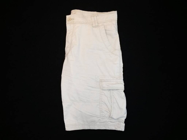 Pantalones cortos de color beige, lateral, sobre fondo negro, imagen - Foto, Imagen