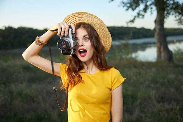 驚きの女性とともにカメライエローtシャツ帽子夏の自然ライフスタイル - 写真・画像