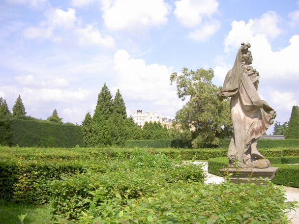 Statue of a woman or man in a castle park, in background Lednice castle, Czech Republic, image - Zdjęcie, obraz