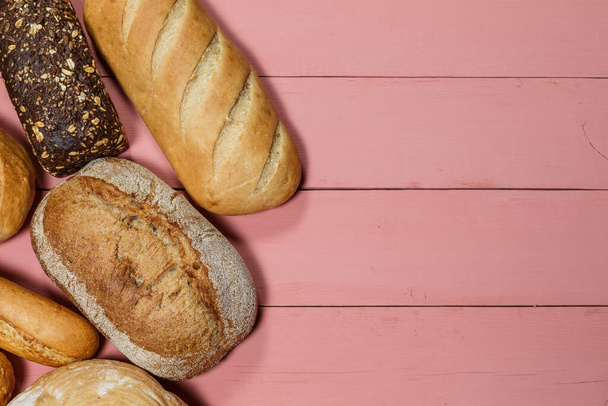 Assorted loaves of fresh gluten free bread on pink background - Zdjęcie, obraz