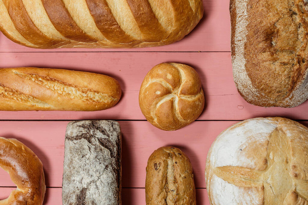 Assorted loaves of fresh gluten free bread on pink background - Foto, Imagem