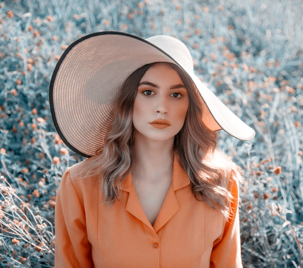 Portrait of young woman in hat posing in field  - Фото, изображение