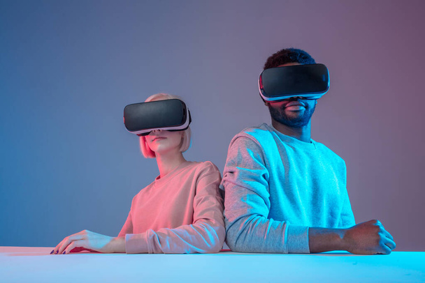 awesome young man and woman in VR glasses posing to the camera - Foto, Bild