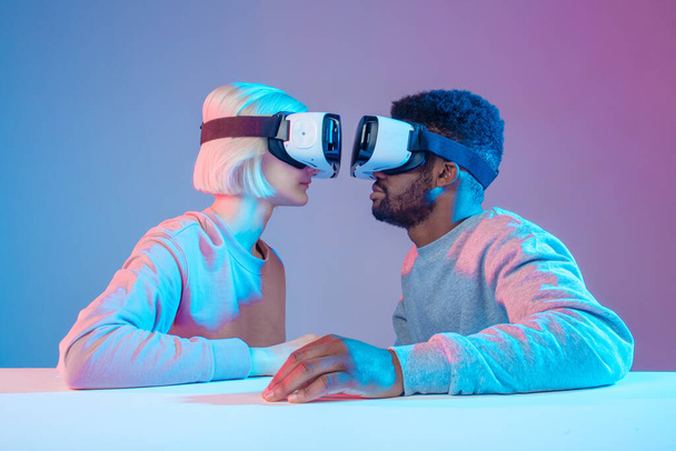 funny people sitting in front of each other and using virtual reality goggles - Foto, imagen