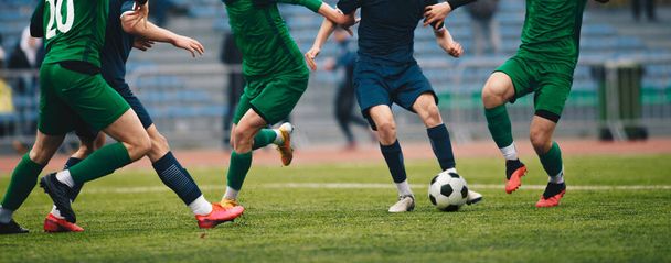 Ποδοσφαιριστές σε δράση στο παιχνίδι τουρνουά. Ποδόσφαιρο παίκτες που ανταγωνίζονται για μπάλα και μπάλα κλωτσιά κατά τη διάρκεια του αγώνα στο γήπεδο. Διαγωνισμός ποδοσφαίρου ενηλίκων - Φωτογραφία, εικόνα