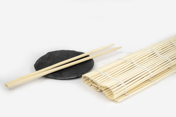 Japanische Küche Hintergrund mit Bambusmatte, Essstäbchen, Sojasauce - Foto, Bild