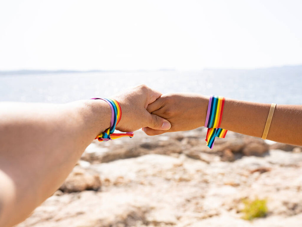 mano insieme coppia sulla spiaggia con braccialetto - Foto, immagini