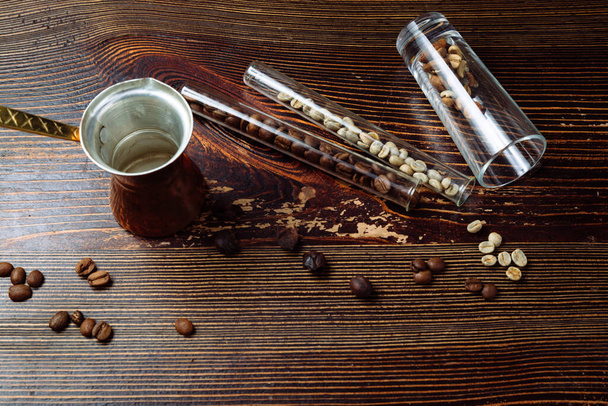 Koffie cezve en koffiebonen op houten achtergrond. - Foto, afbeelding