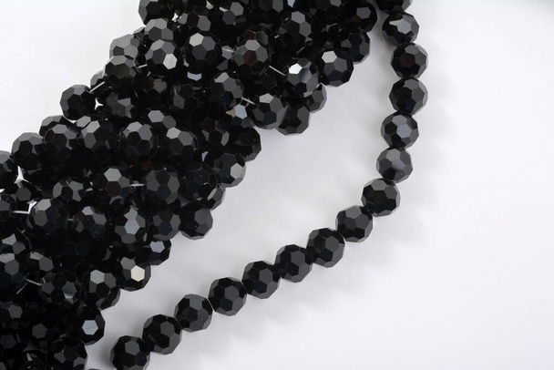Hermosas perlas de cristal de la chispa de cristal negro sobre fondo blanco. Uso para joyería de cuentas de bricolaje - Foto, imagen