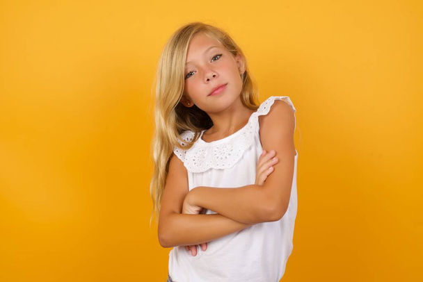 cute  girl  with arms crossed  on yellow background  - Fotó, kép