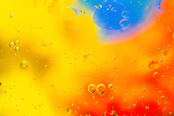 Abstract kleurrijke achtergrond olie in het water met kleurrijke gradiënt kleuren. Fantastische structuur van kleurrijke oliebellen. Chaotische beweging. Psychedelisch patroon afbeelding regenboog gekleurd. Macro-injectie. - Foto, afbeelding