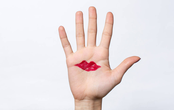 drawn red lips on female palm hand. isolated - 写真・画像