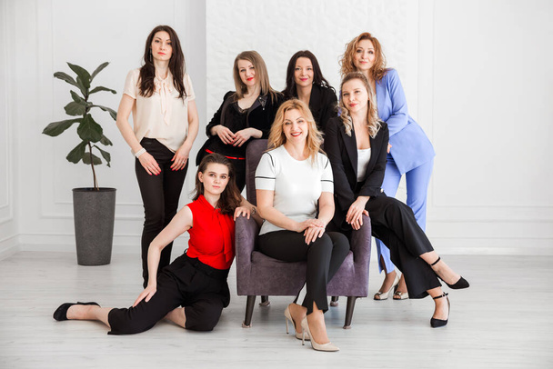 Szczęśliwe kobiety pracują zespół pracowników grupy patrząc na aparat pozowanie w studio, uśmiechnięte kobiety pracowników firmy, pracowników, menedżerów biznesu stojących razem, portret. Zdjęcie poziome - Zdjęcie, obraz