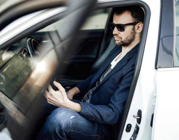 Ein Unternehmer in seinem Auto fährt, um Geschäfte zu machen - Foto, Bild