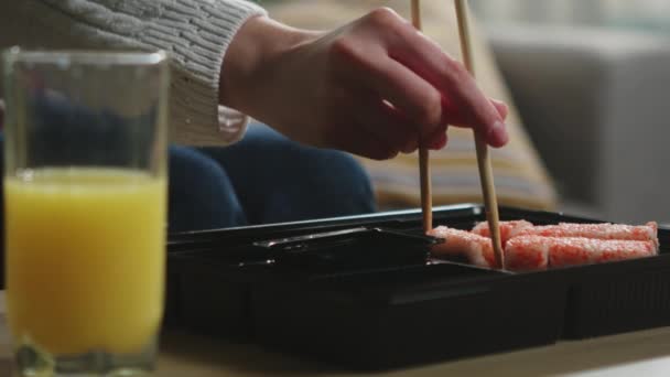 Dziewczyny z pałeczkami bierze sushi i zanurza w sosie sojowym - Materiał filmowy, wideo