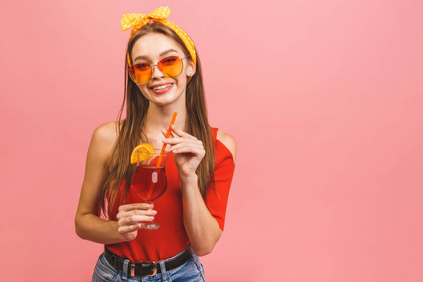 Primer plano retrato de atractiva chica encantadora sosteniendo bebida de cóctel aislado sobre fondo rosa. - Foto, imagen