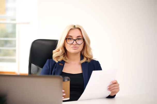 smiling blonde businesswoman with glasses using laptop in the office - Φωτογραφία, εικόνα