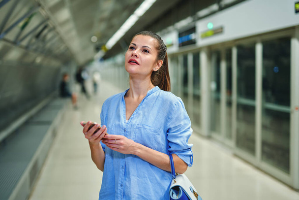 молода жінка з сумкою на станції метро
. - Фото, зображення