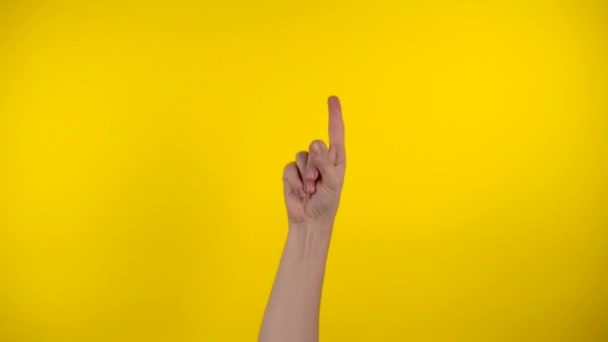 Aparezca la mano, haciendo gestos con la mano sobre fondo amarillo - Metraje, vídeo