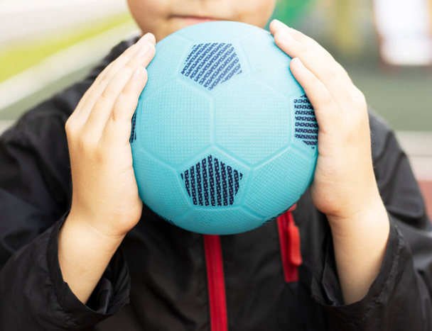 baby boy holding a blue ball in his hands. love of sport. healthy lifestyle - Fotoğraf, Görsel