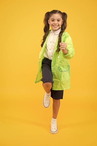 enjoy autumn rain. amazing discounts. small girl have fun in raincoat. active schoolgirl waterproof cloak. water resistant clothes. in good mood. Rainproof accessory. Autumn fashion for kids - Photo, image
