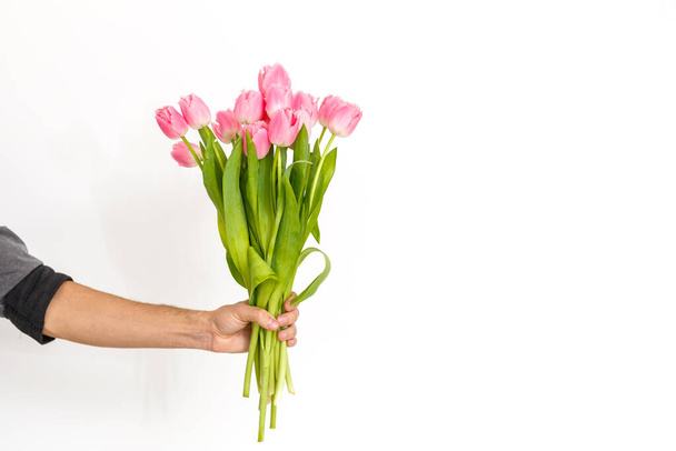 Um homem com flores. Homem romântico com buquê de tulipas para o aniversário. Feliz Dia da Mulher. Dando buquê de flores. Um homem bonito a dar flores. Fundo branco. Fotografias horizontais - Foto, Imagem