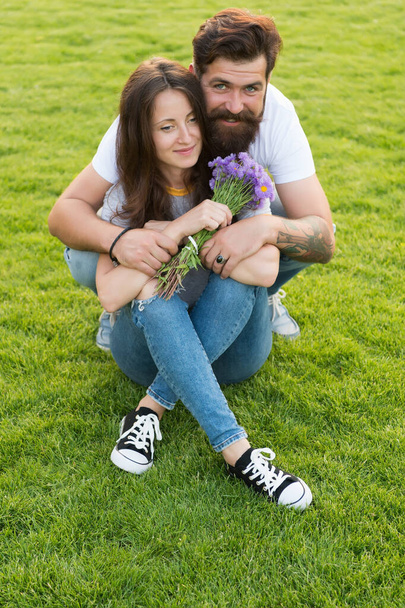 Lovely couple cuddling relaxing on green meadow, celebrate anniversary concept - Photo, image