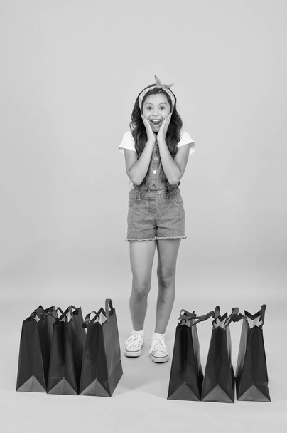 Shocking discount. Shopping day. Fashion boutique. Girl shopping. Fashion shop. Little girl with shopping packages. Happy child in shop with bags. Small child in summer style. Seasonal sales - Foto, afbeelding