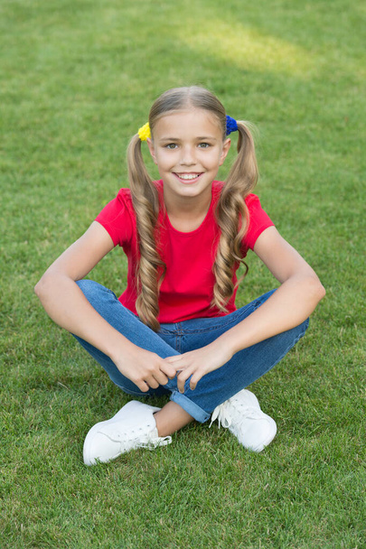 Little girl cute ponytails hairstyle relaxing on green grass, summer vacation concept - Foto, Bild