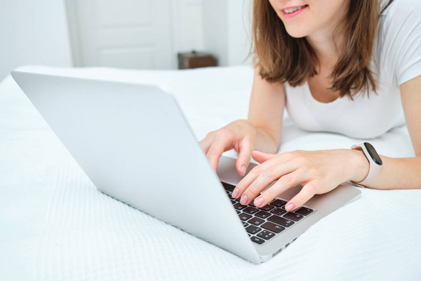 Giovane donna caucasica utilizza il computer portatile a casa. - Foto, immagini