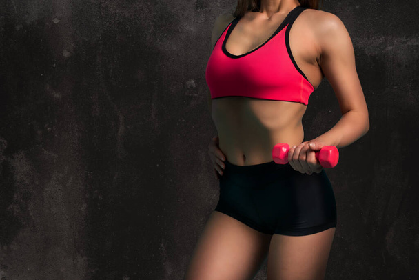 Mulher muscular está treinando com halteres de peso no ginásio - Foto, Imagem