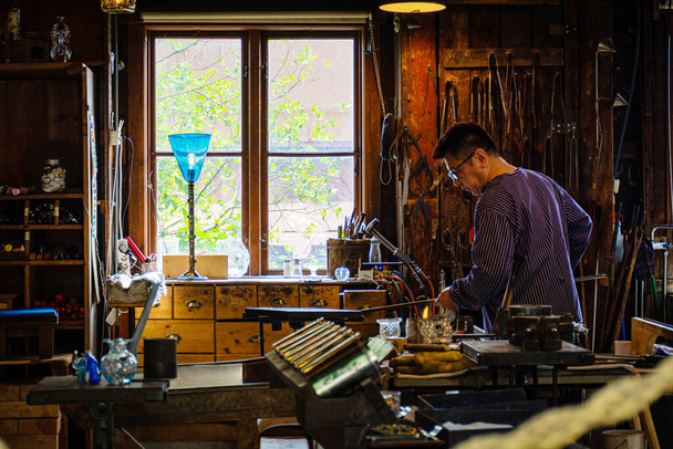 STOCKHOLM, SWEDEN - Jun 18, 2019: Artisan making glass in an old glass factory. Stockholms traditional glass workshop that can be found in Skansen. - 写真・画像