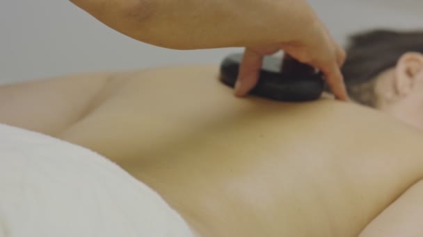 Piedras que se ponen en las mujeres de nuevo durante el masaje - Imágenes, Vídeo
