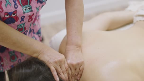 Massaggiatrici mani dando un'altra donna un massaggio al collo in spa - Filmati, video