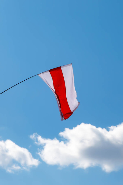 Бело-красно-белый флаг на синем фоне неба. Исторический флаг Белоруссии. - Фото, изображение