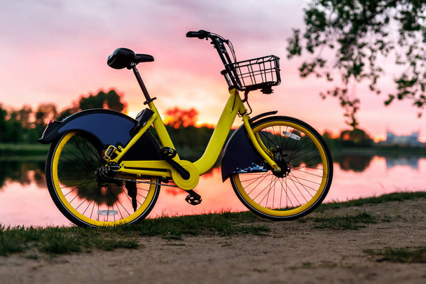 Yellow bike on the lake. Sunset. - Photo, Image