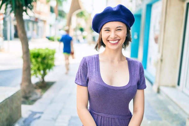 Νεαρό όμορφο κορίτσι χαμογελώντας χαρούμενος με γαλλικό στυλ το περπάτημα στο δρόμο της πόλης - Φωτογραφία, εικόνα