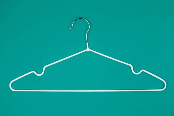 White clothes hanger on turquoise background. Top view Shopping, sale, promo, new season concept. - Photo, Image