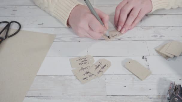 Step by step. Labeling brown paper gift tags with a black marker. - Footage, Video