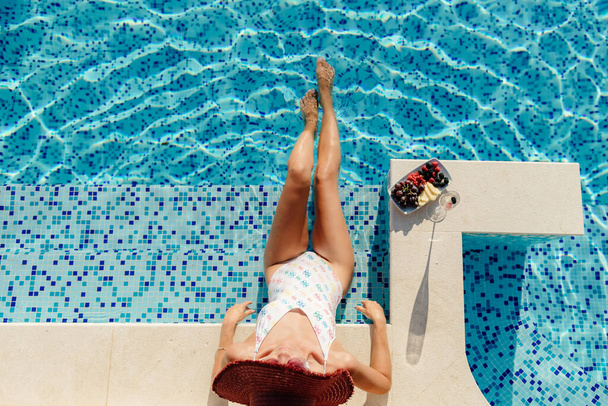 жінка відпочиває в басейні і п'є шампанське
 - Фото, зображення